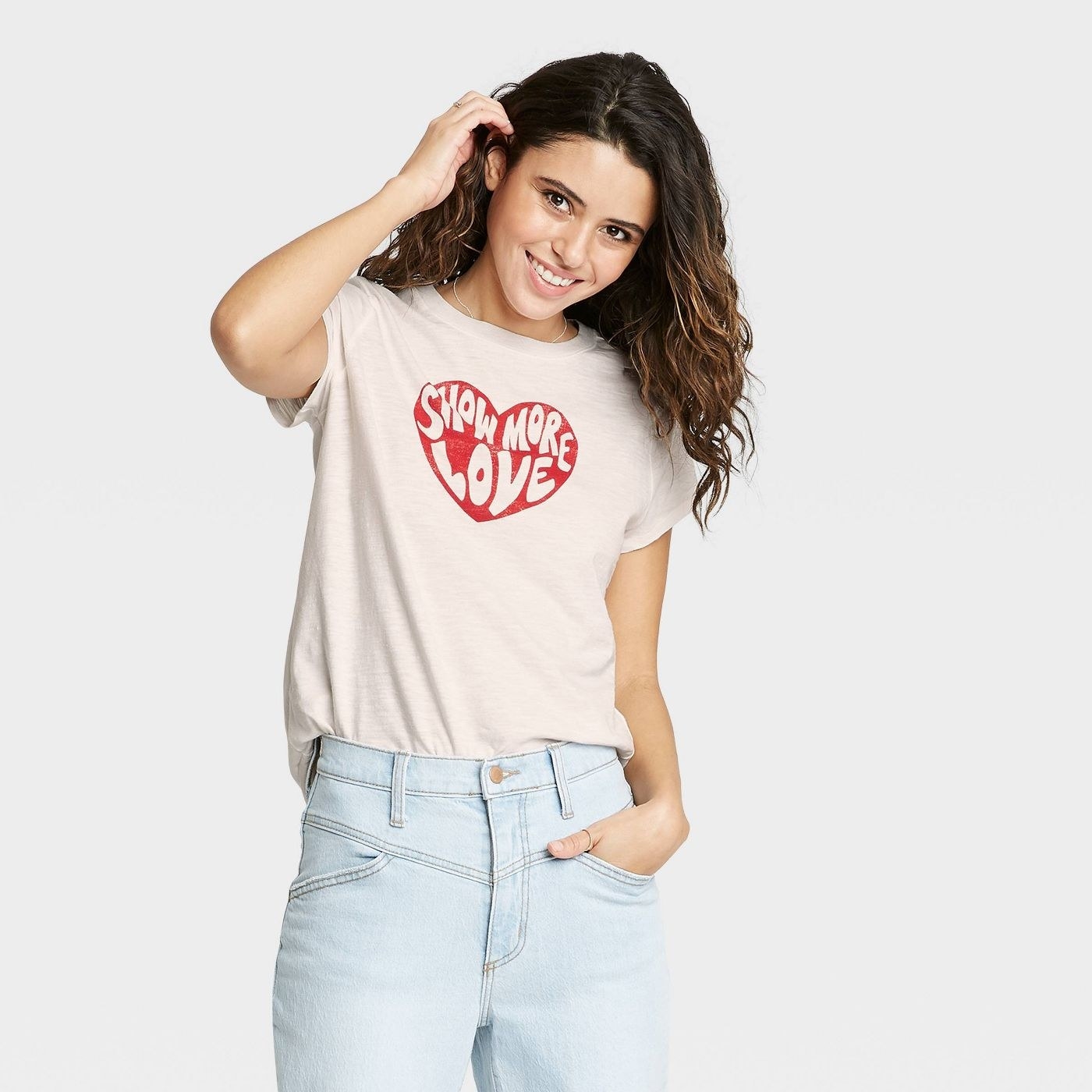 A model wearing a white T-shirt with a red heart