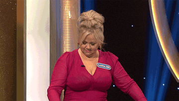 Caroline Rhea spins the wheel with both hands.