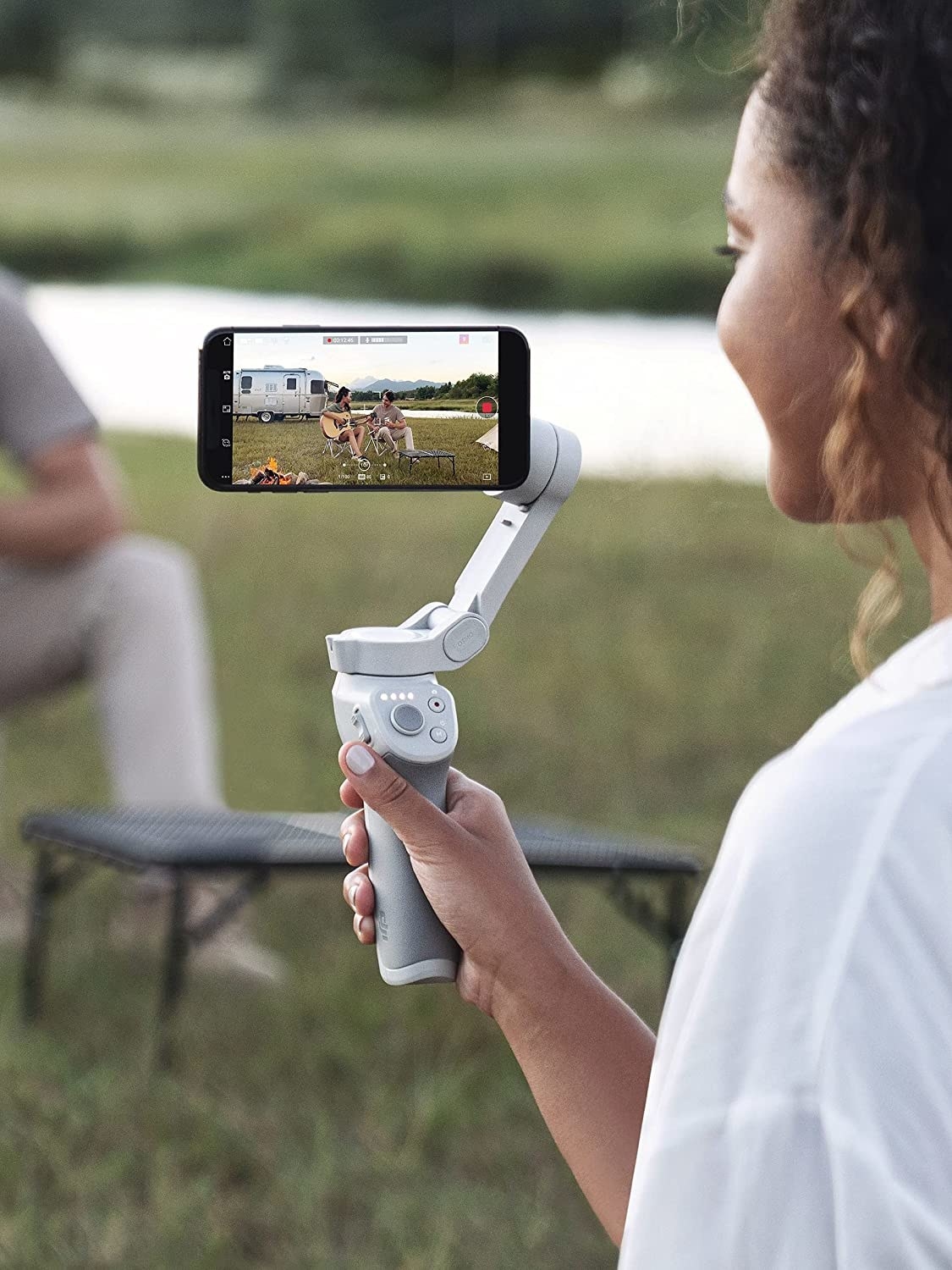 A person using the self-stabilizing tripod while filming a video on their phone