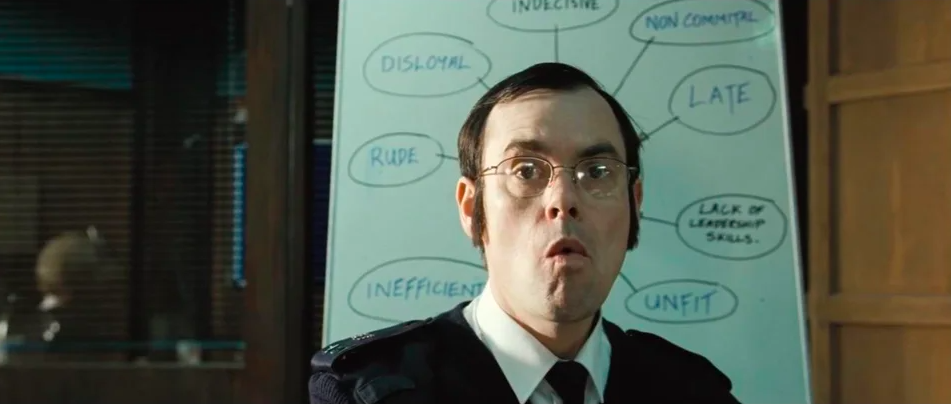 There are thought bubbles on a whiteboard in the background that are framed around a police officer, so the words, like rude and late, look to be about him