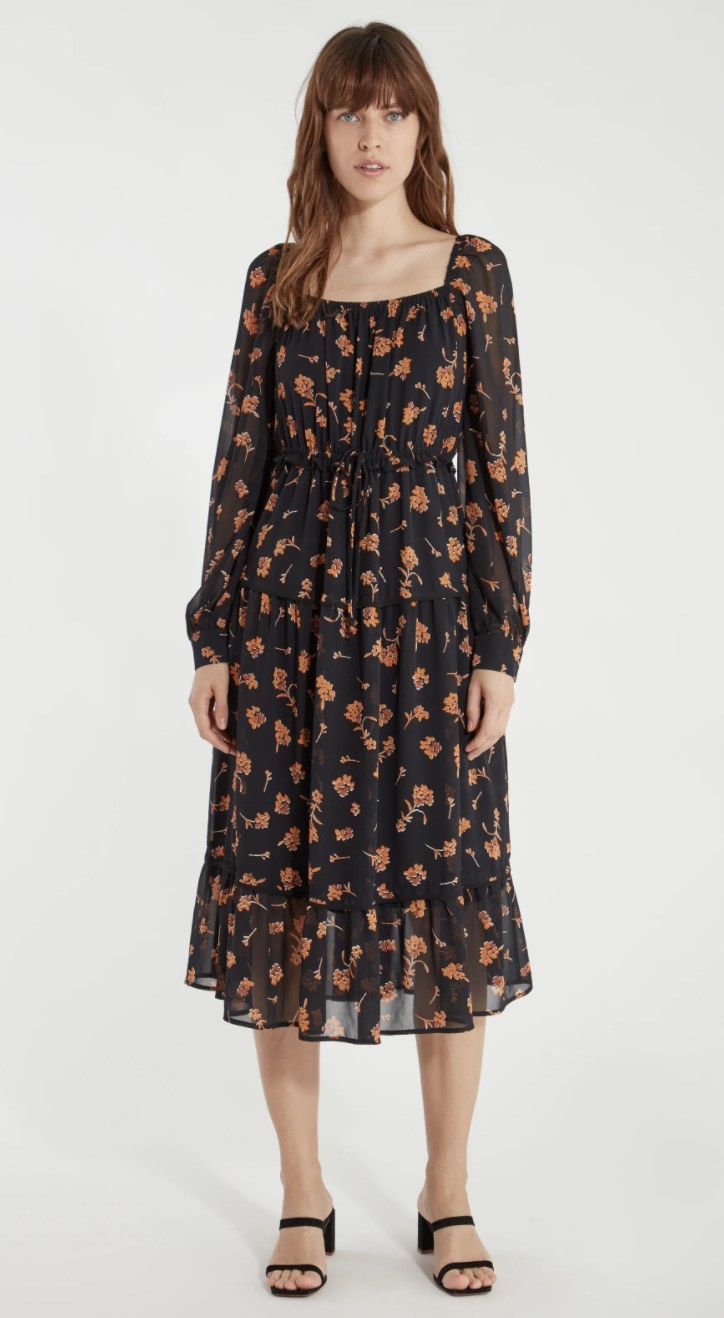 model wearing black and orange floral dress