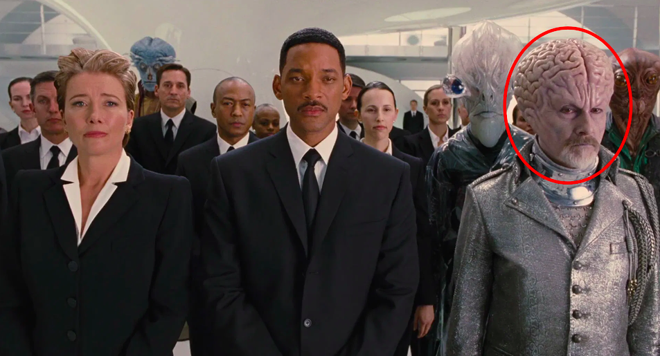 Rick Baker in full makeup next to Will Smith and Emma Thompson in a scene