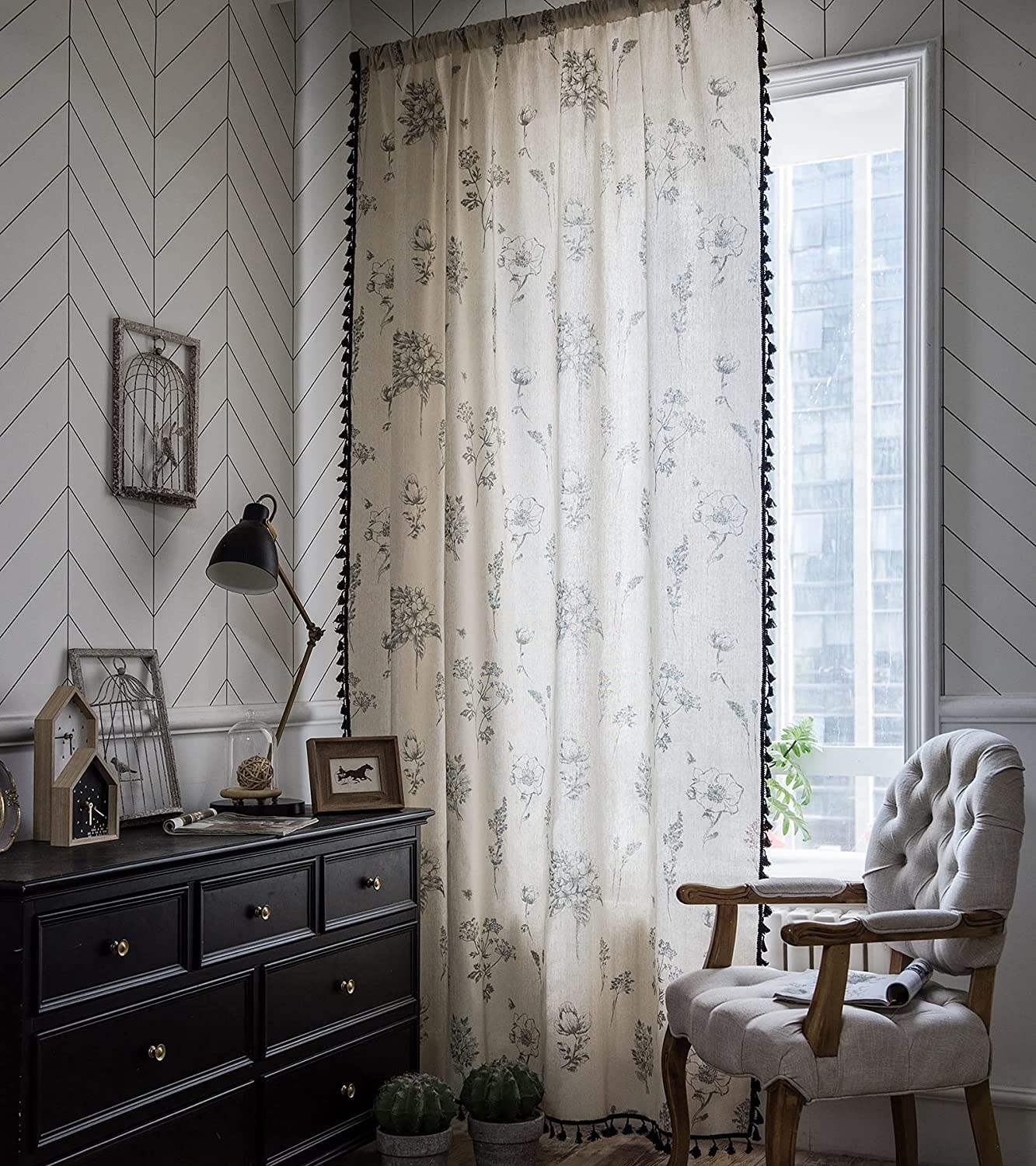 floral curtains with pom pom trim on them in a living room