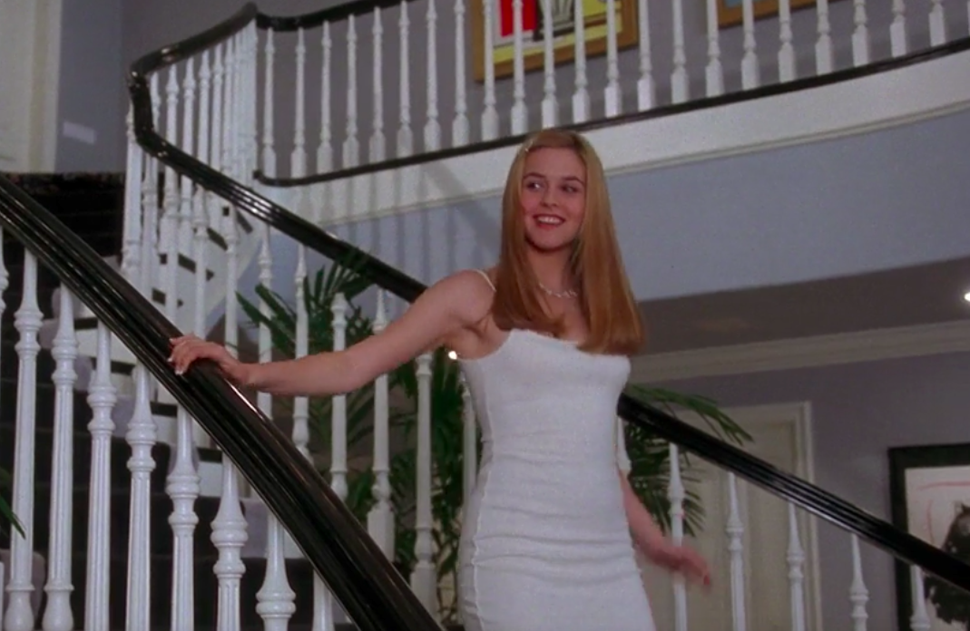 Cher coming down the stairs in a slinky white dress