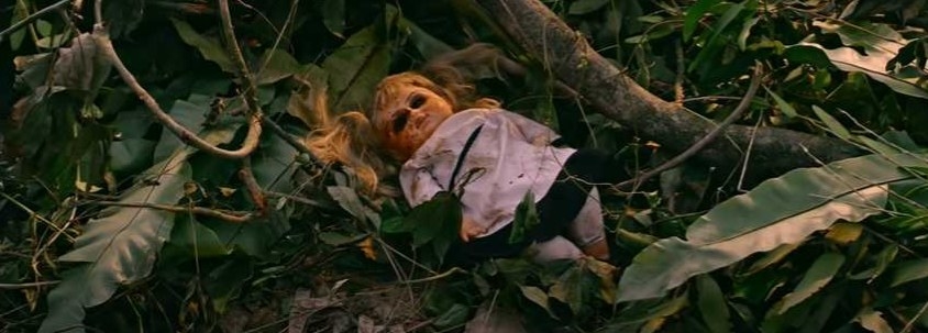 Creepy doll lays in branches