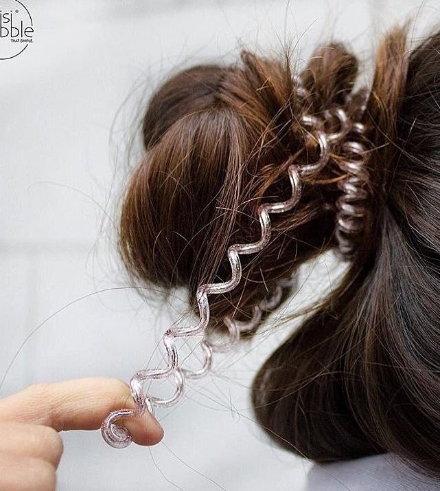 a person tugging on the hair coil in their hair