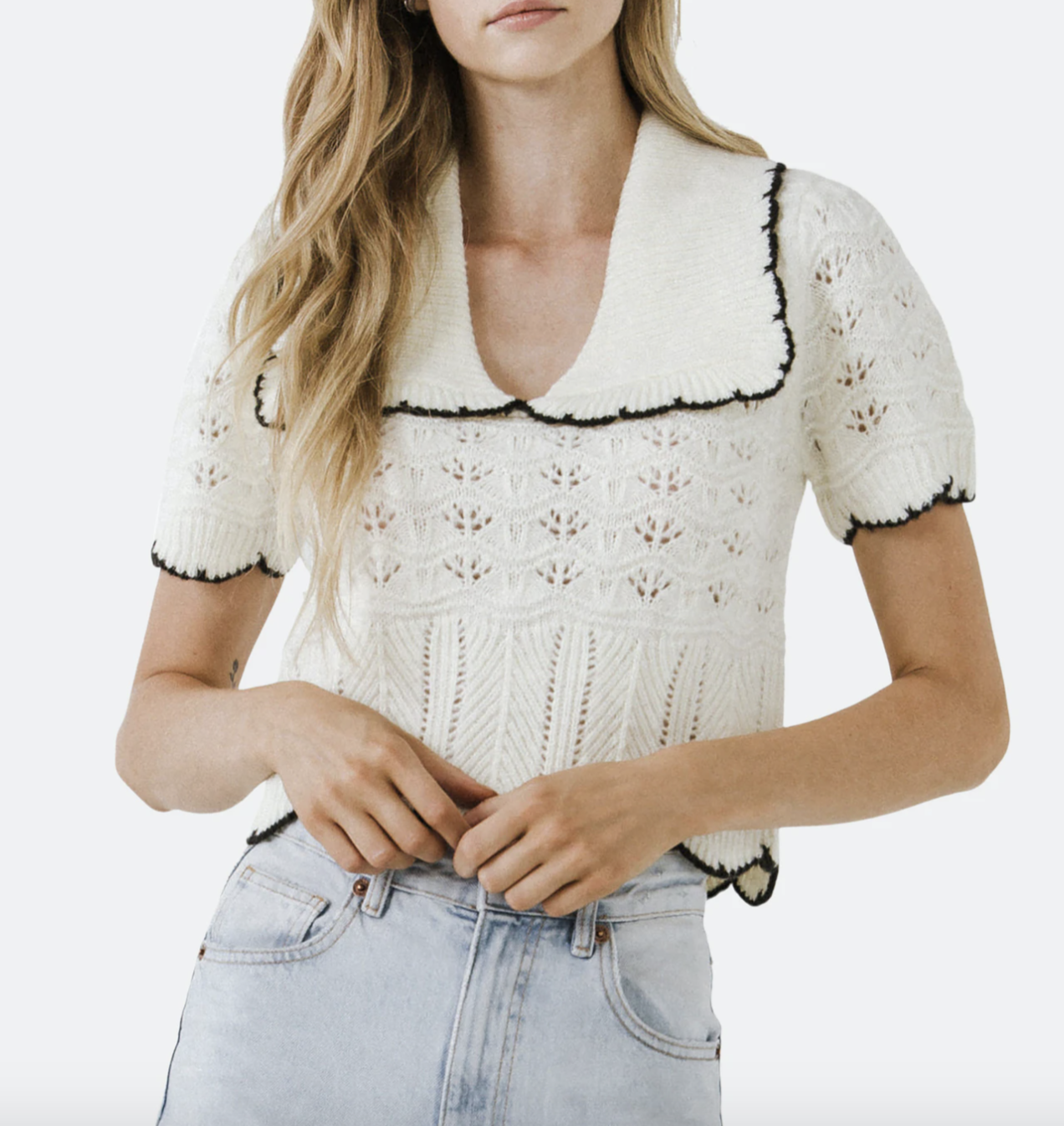 A model wearing the Short Puff Sleeve Scalloped Knit Top in white