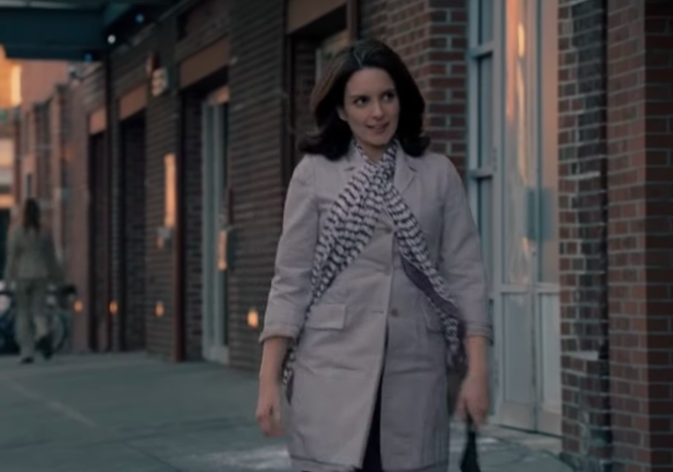 Tina Fey wearing a striped scarf over a trench coat