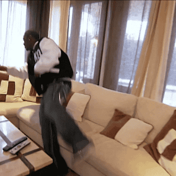 GIF of Ray J leaping onto a couch