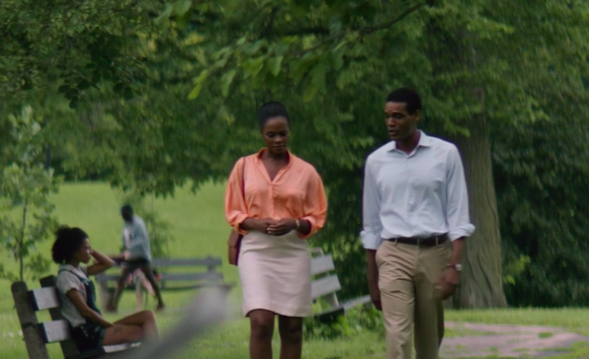Michelle and Barack walking through a park