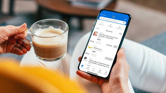 Image of model holding drink in one hand and phone in the other looking at Walmart app