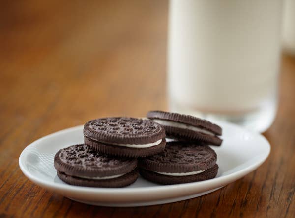 A plate of Oreos next to a glass of milk