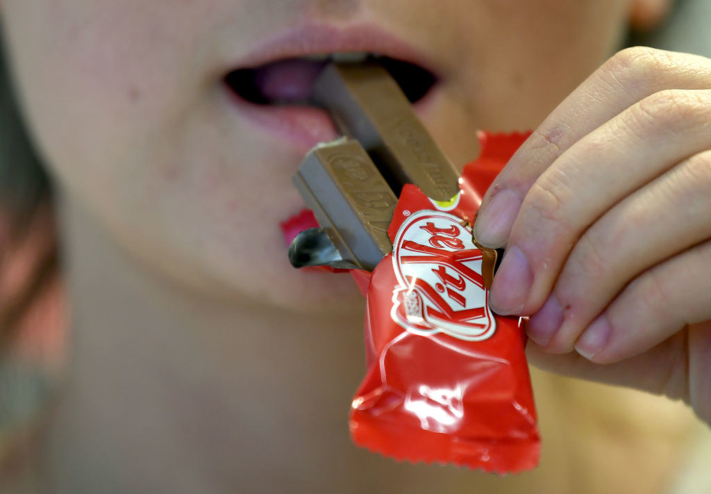 Someone bites into a Kit Kat bar