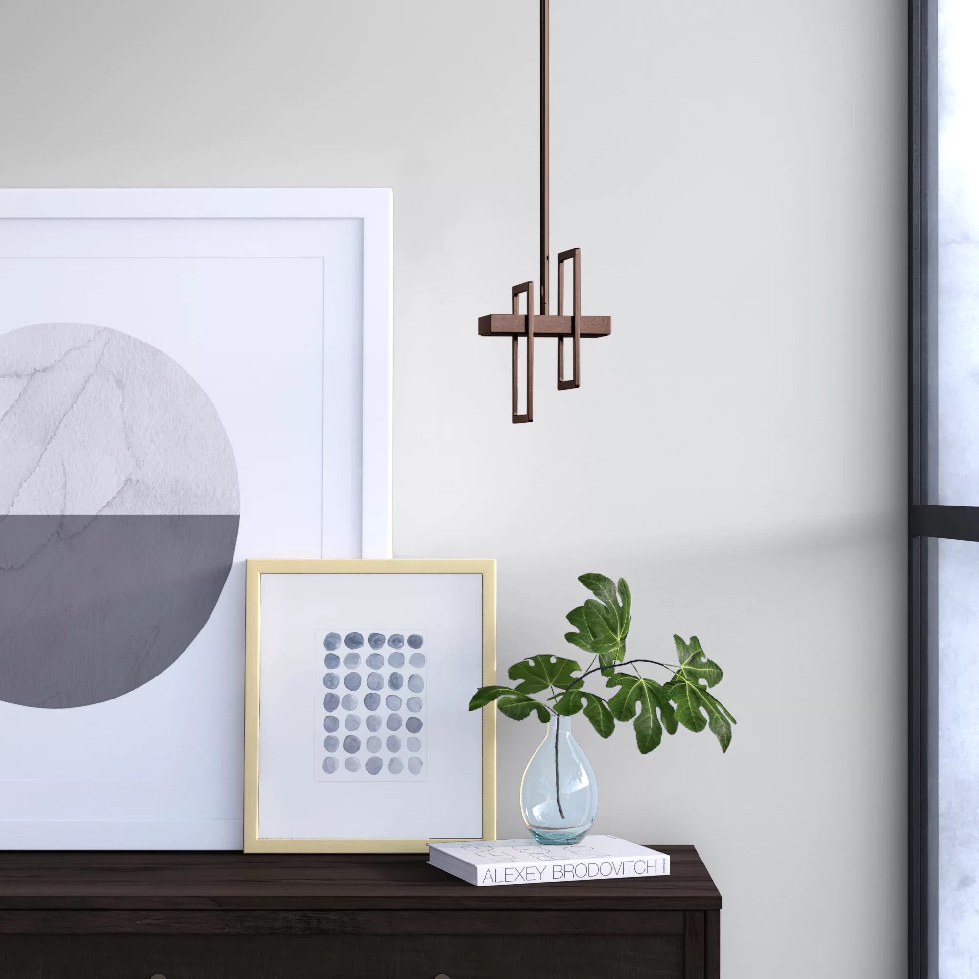 A geometric light pendant hanging above a houseplant.