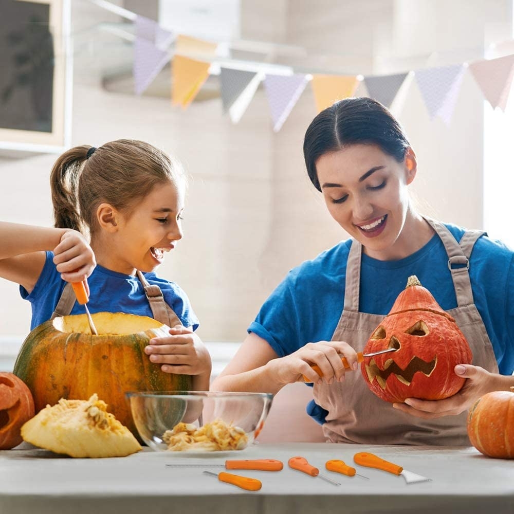 A parent and child carving pumpkins