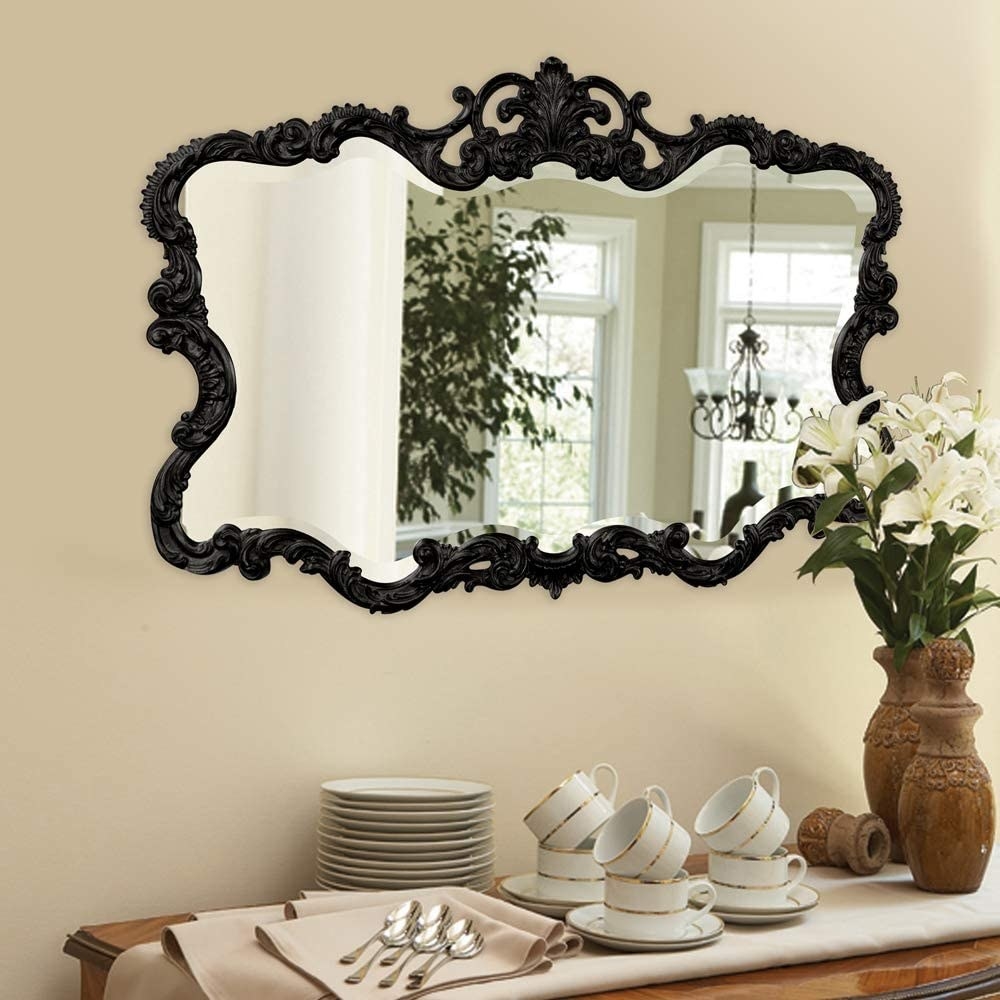 black vintage looking mirror on the wall over a buffet