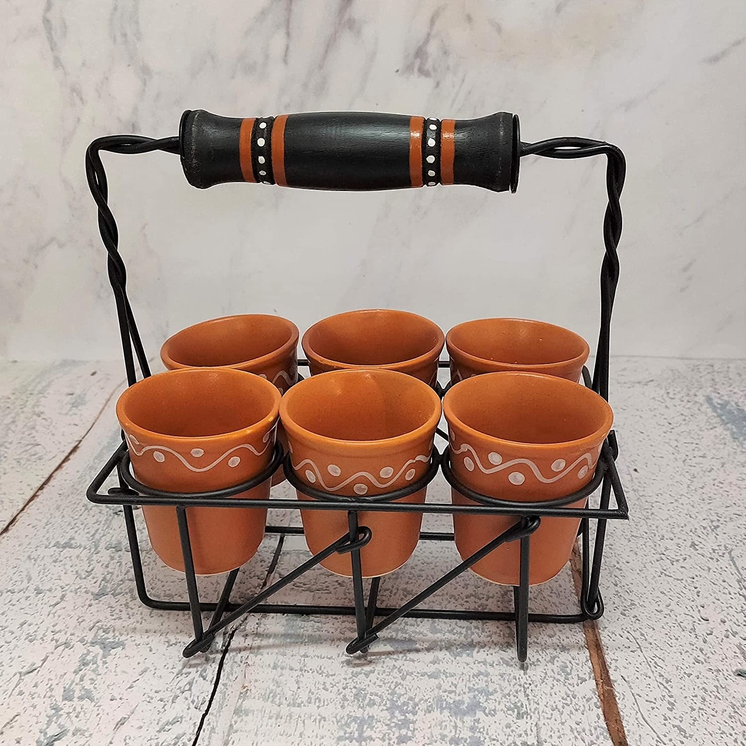 A cutting chai holder with cups in it