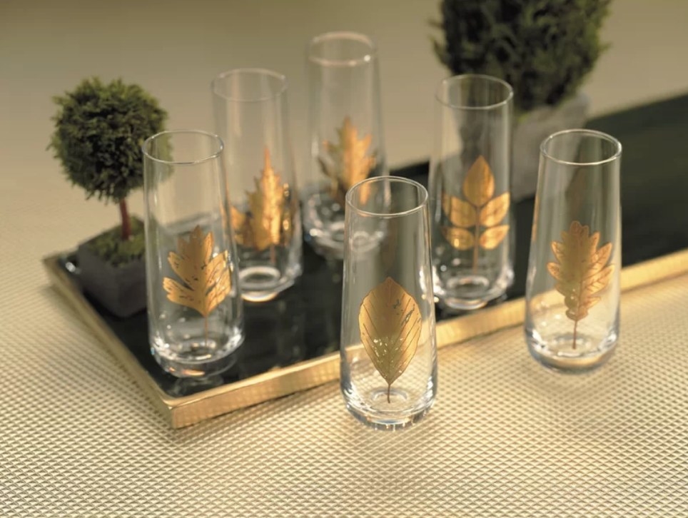 A set of six stemless wine glasses with a gold leaf detail