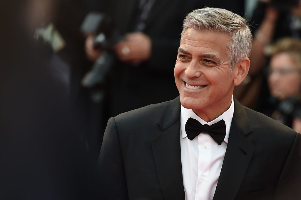 George Clooney, in a bow tie, smiles and walks the red carpet ahead of the &quot;Suburbicon&quot; screening
