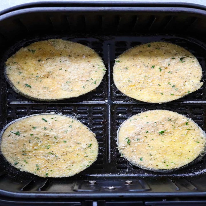Dredged eggplant slices in the air fryer.