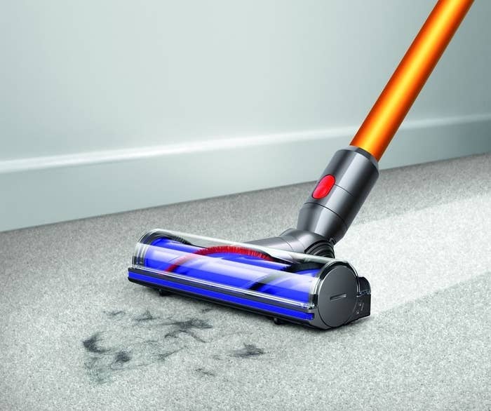 A vacuum cleaner getting ink stains off a carpet