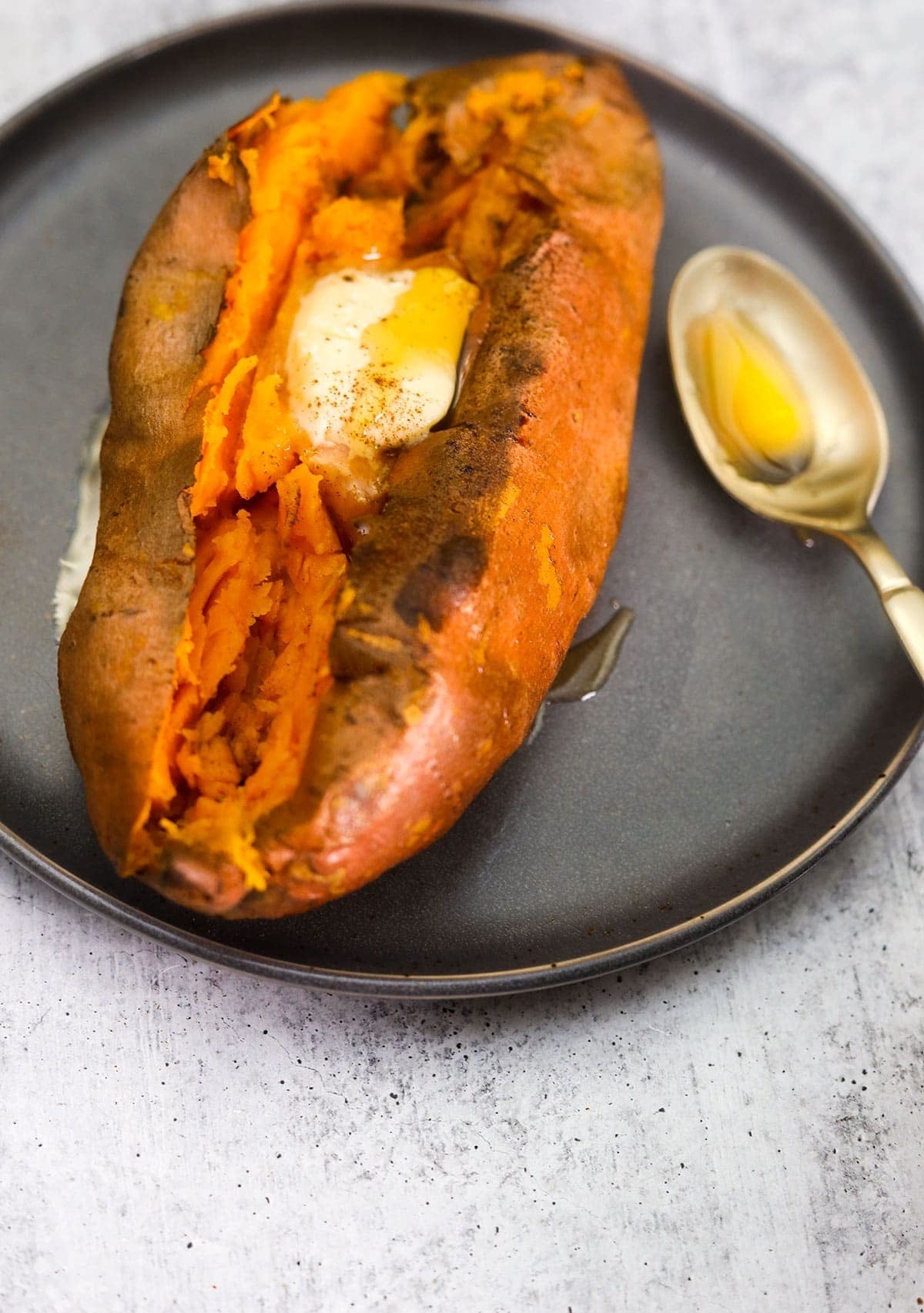 Air fryer &quot;baked&quot; sweet potato topped with butter and cinnamon.