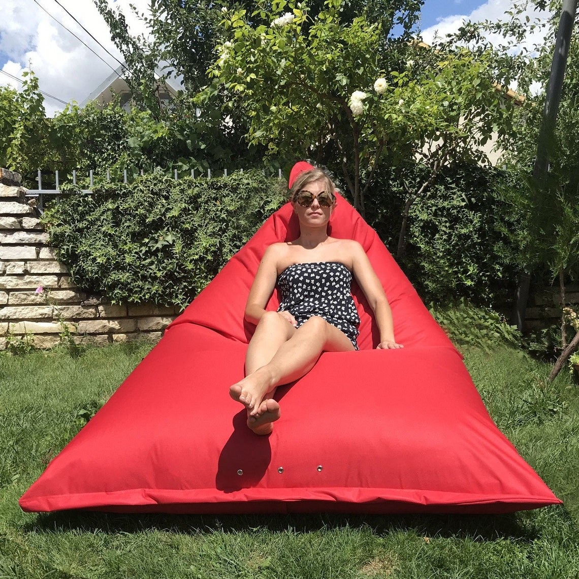 Model sitting on red bean bag chair