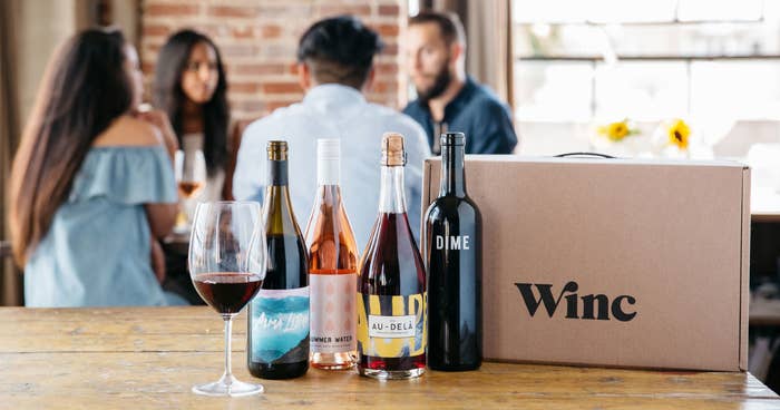 four bottles of wine next to a Winc box