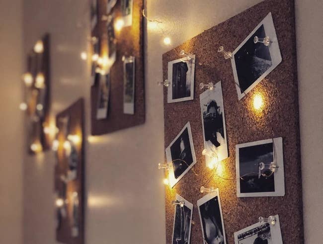 Reviewer photo of the twinkle lights on cork boards surrounding polaroid pictures
