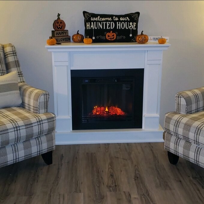 A reviewer&#x27;s photo of the white fireplace