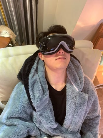 Reviewer is wearing the eye mask while tilting their head back on a chair