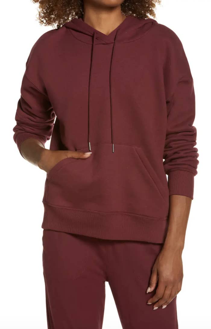 model in burgundy hoodie