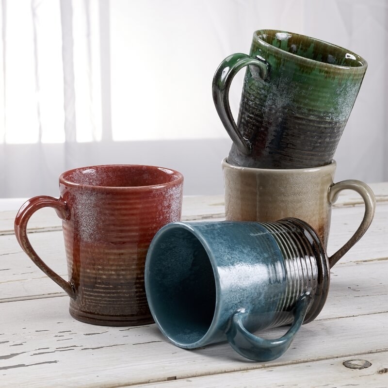 The red, blue, tan, and green mugs