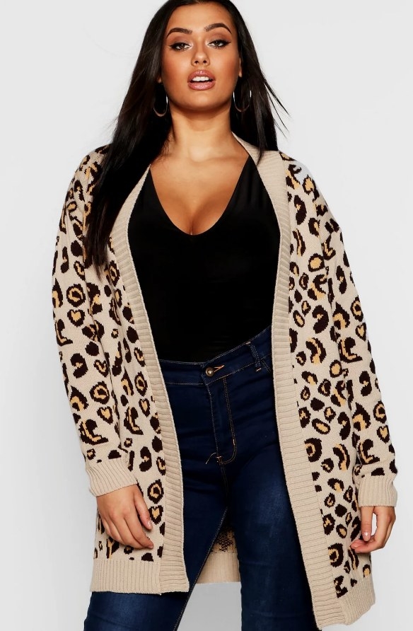 Model wearing beige leopard cardigan over black shirt with jeans