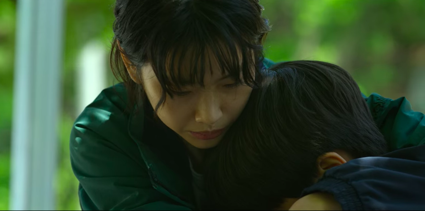 Sae-byeok looking down and hugging someone else