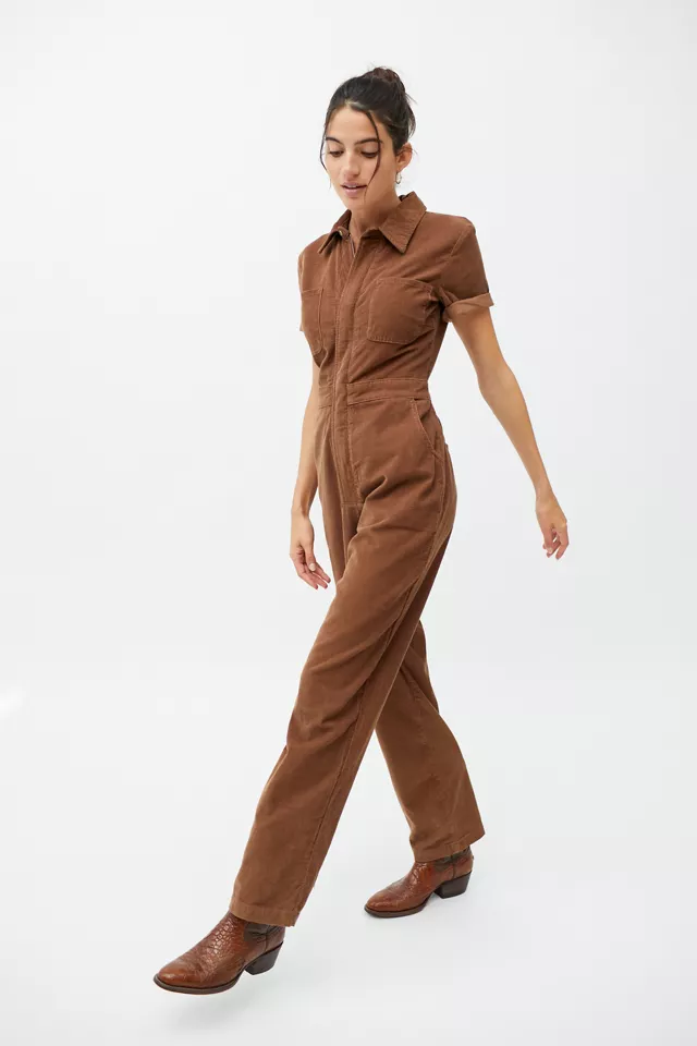A person wearing a short sleeved jumpsuit with boots
