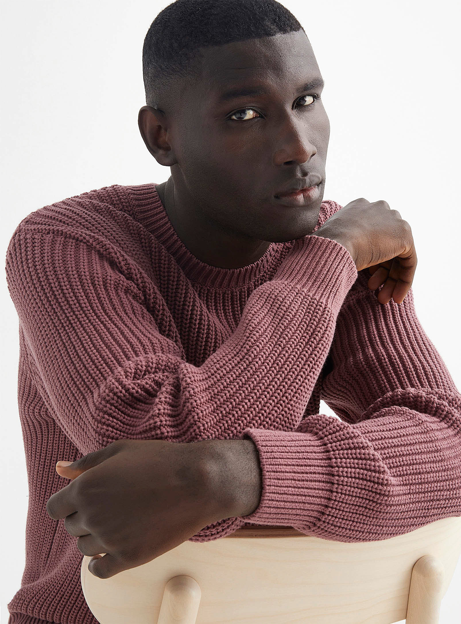 A person wearing a chunky knit sweater