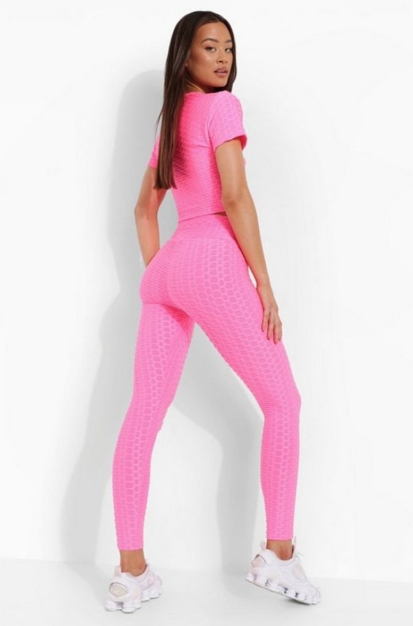 Model wearing hot pink workout leggings with matching crop top