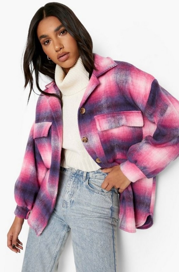 Model wearing pink, purple and white plaid jacket over white turtle neck and jeans