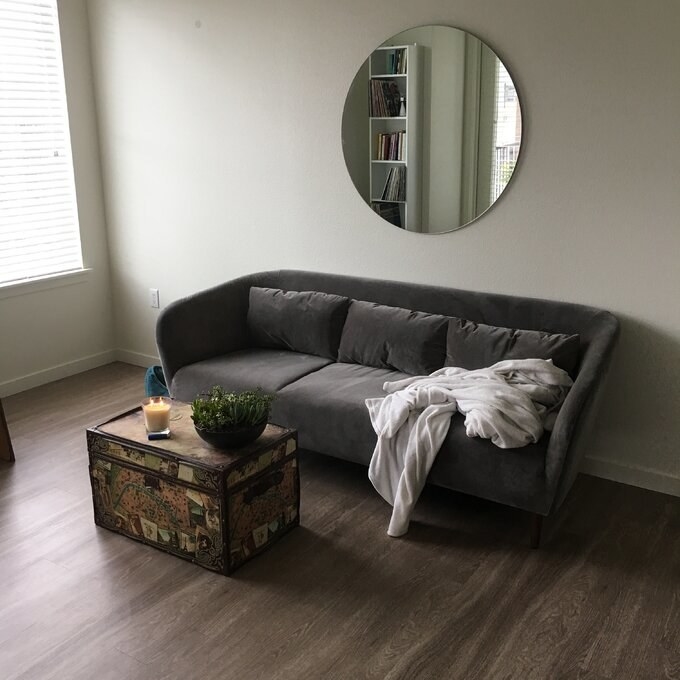 A reviewer&#x27;s photo of the grey velvet couch