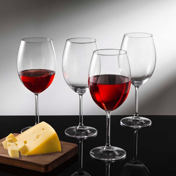 The glasses filled with red wine and served with cheese