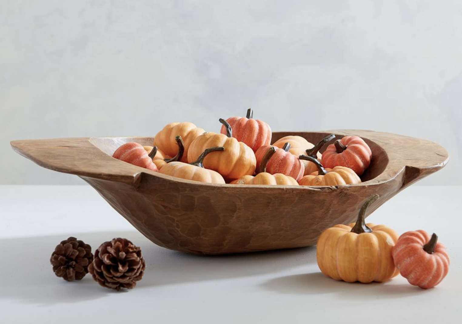 a bunch of small pumpkins in a brown bowl