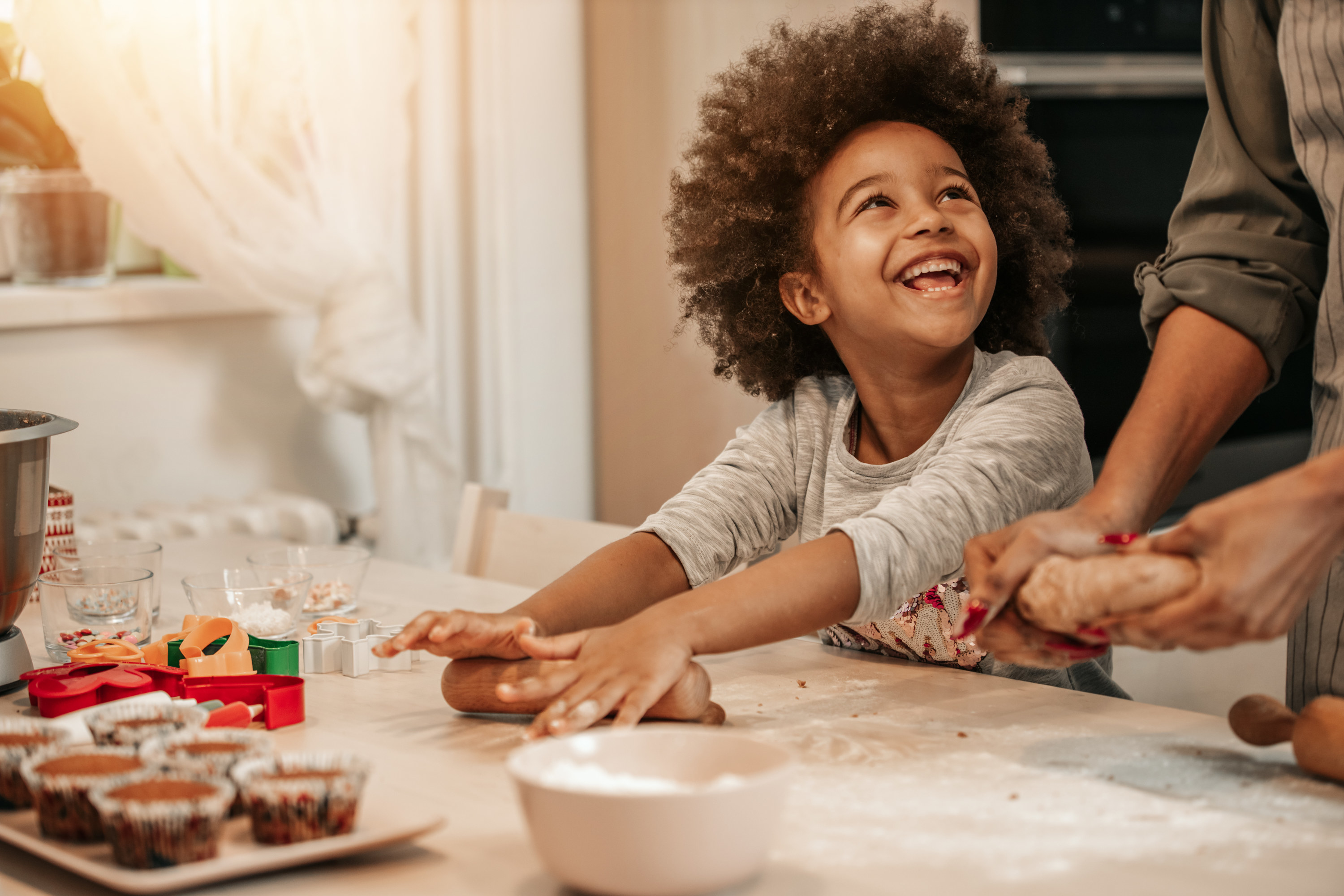 Little girl making cookies with an older relative