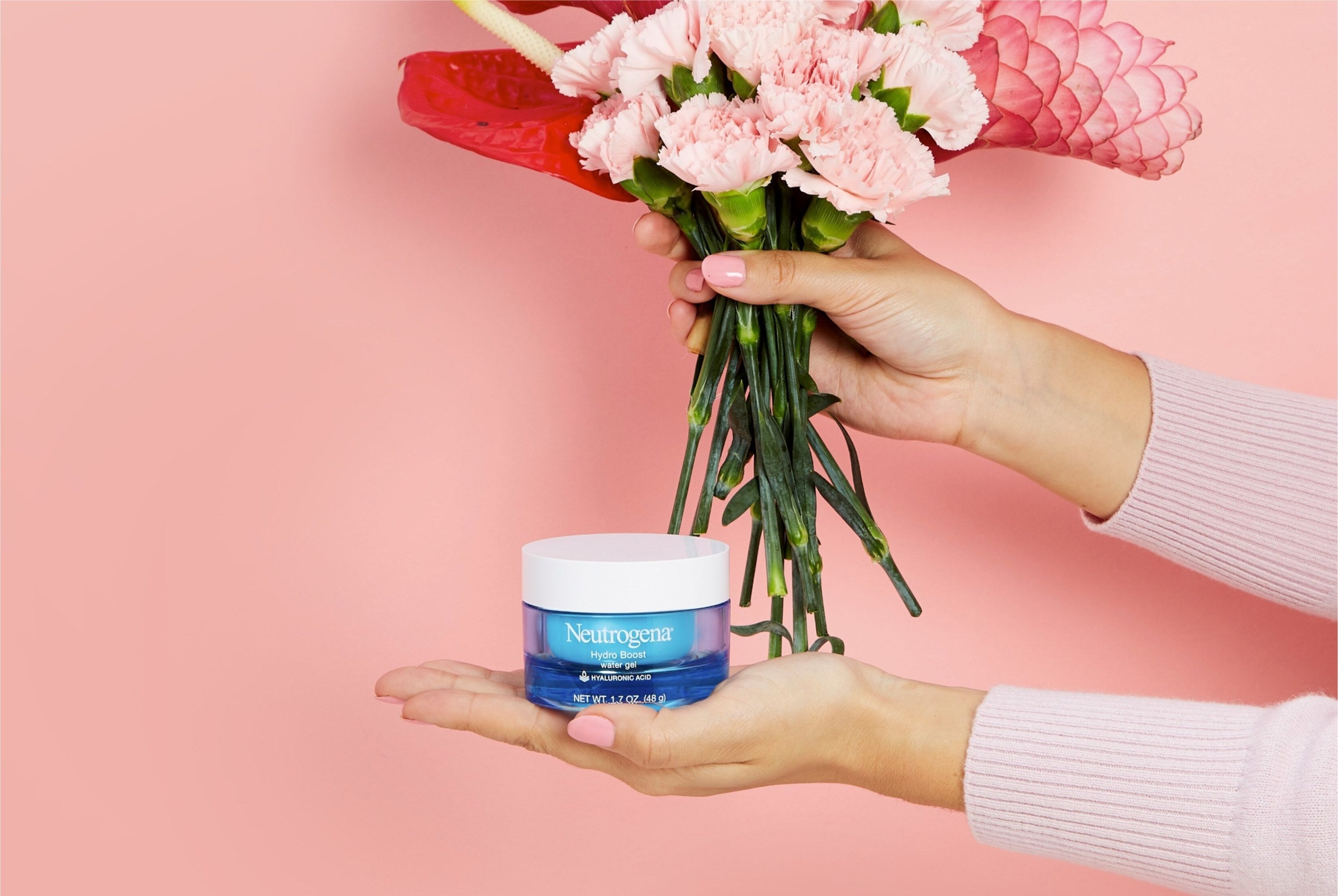 Hands holding moisturizer and flowers