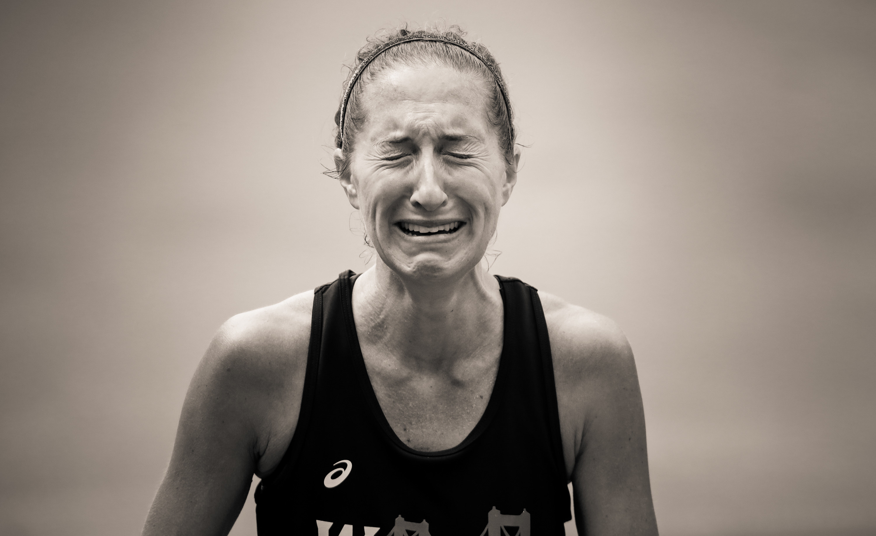 A woman&#x27;s face is contorted with tears as she finishes the marathon