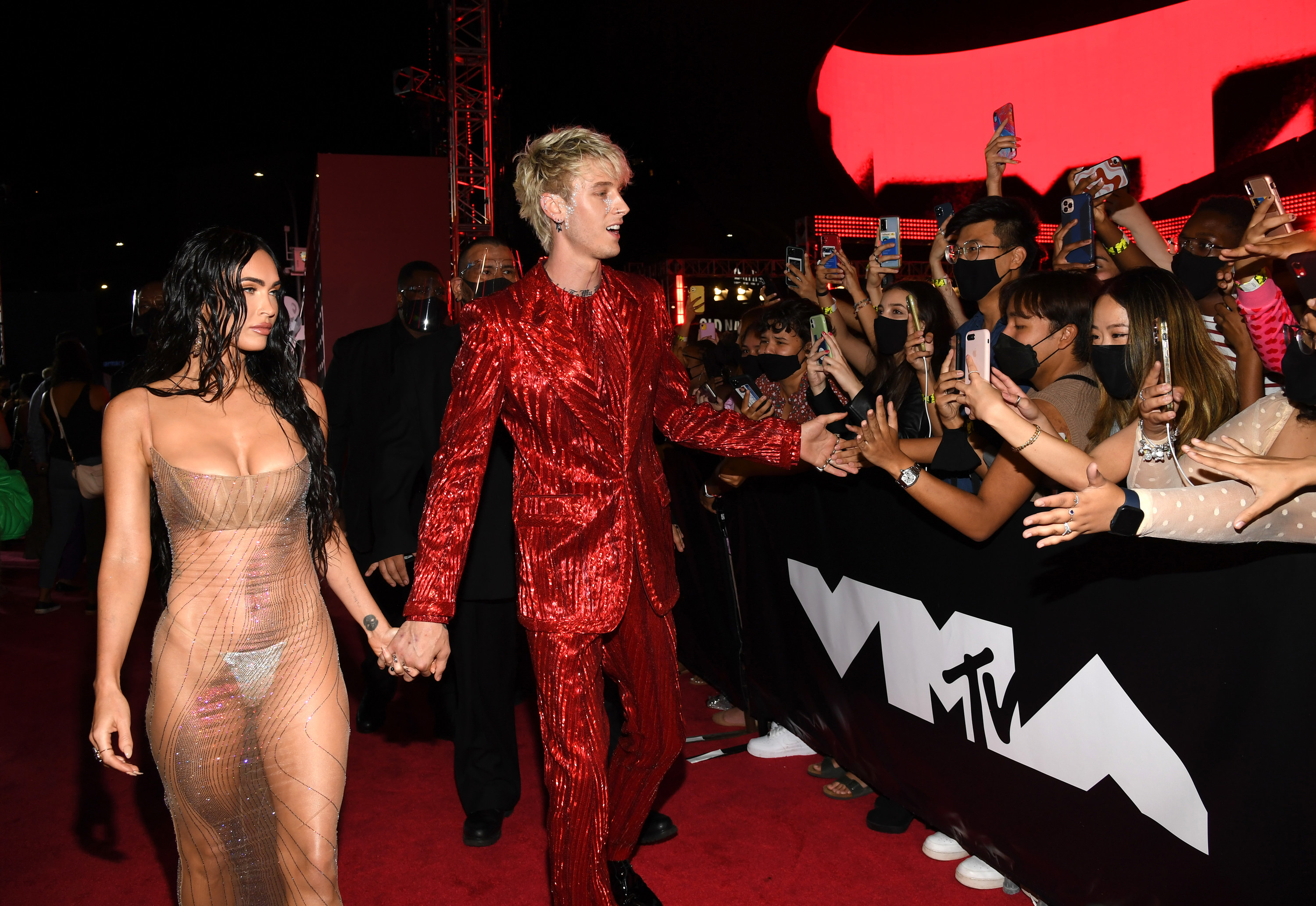 The couple walking hand-in-hand as they pass fans on the MTV VMA red carpet