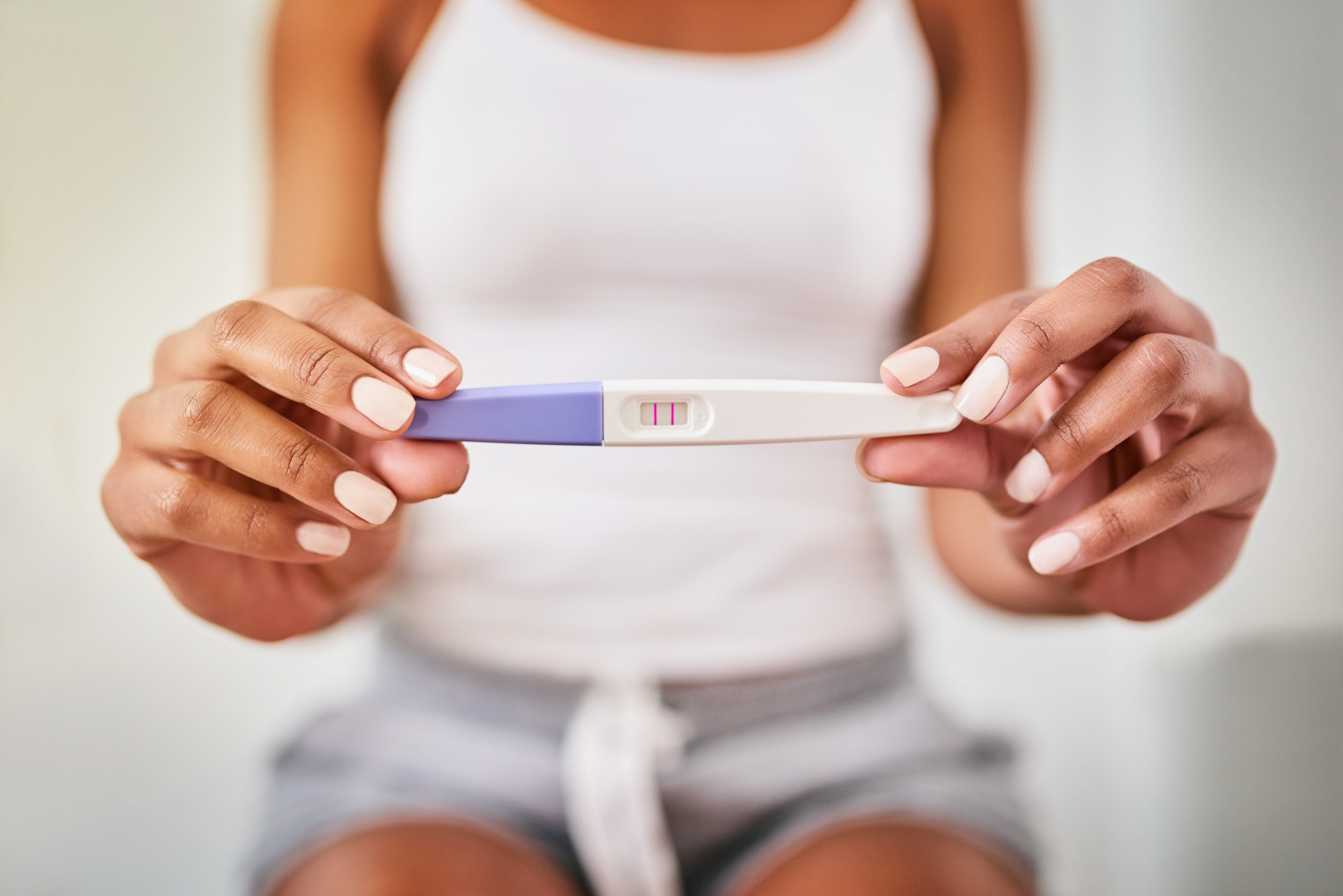 A woman holding up a positive pregnancy test