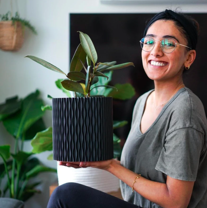 a smiling person holding up the 3D printed planter