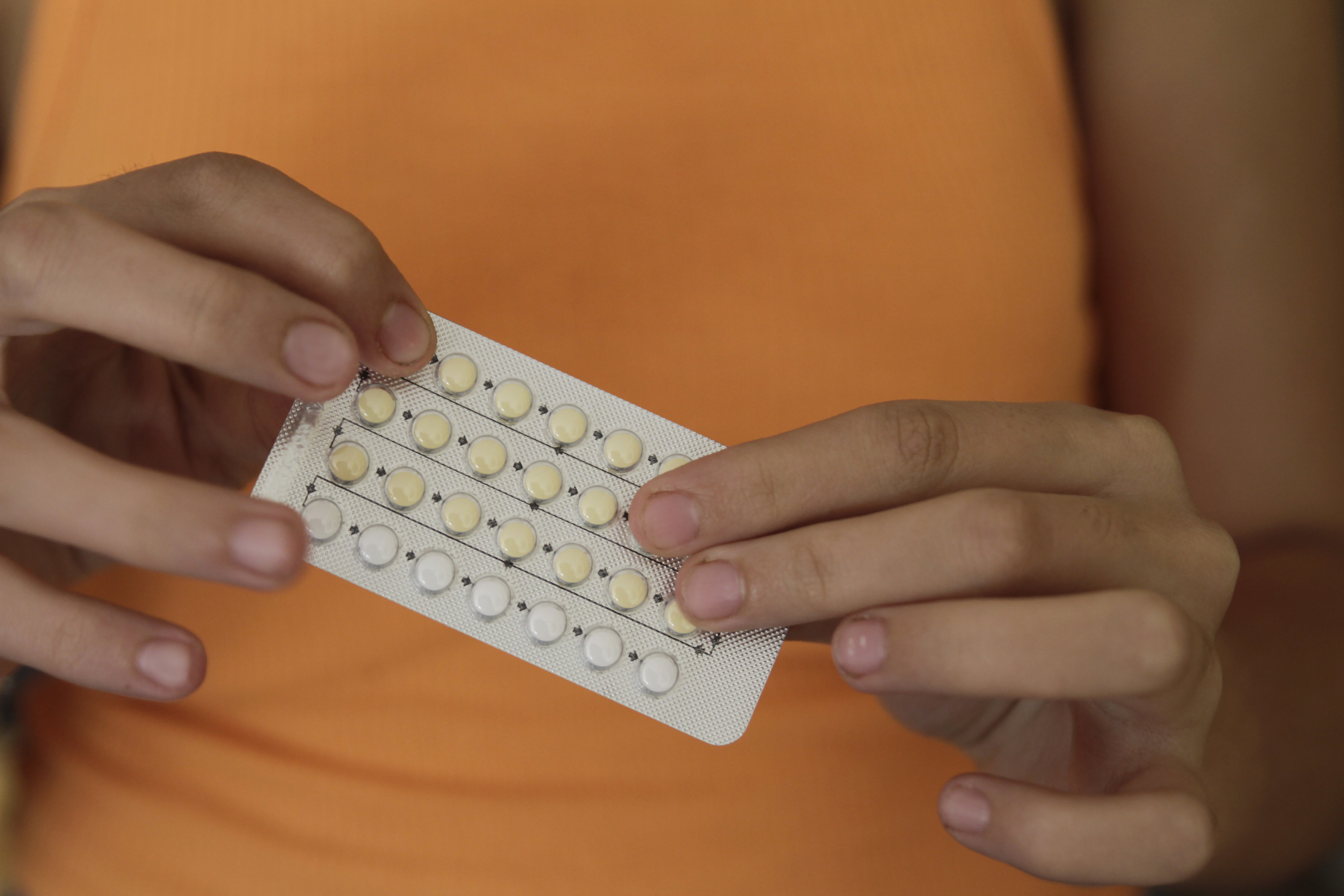Stock image of a person holding a pack of birth control pills