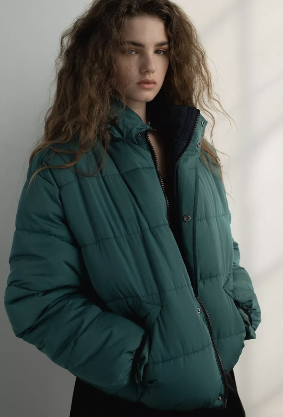 model wearing a teal puffer jacket